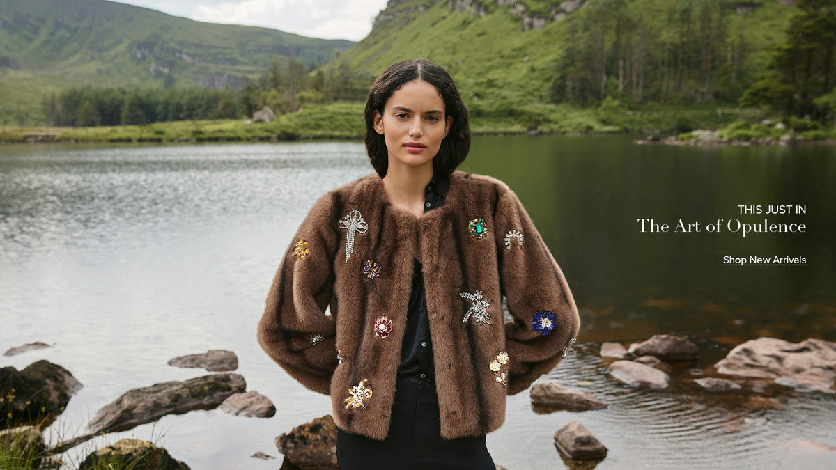 The jewel benson coat on a woman standing in front of a lake.